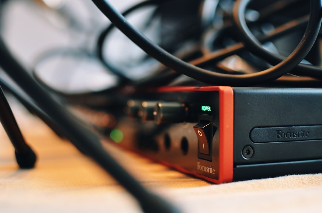 Close-up of an audio mixing console with faders and knobs in a podcast studio
